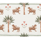 The Matouk Tiger Palm Tabletop Collection features a rectangular placemat adorned with Schumacher's jungle motif—tigers, palm trees, and red flowers—set on a white background with a green border.