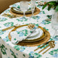 A dining table set with Matouk’s Tillett x Matouk Blue Geranium Table Linen Collection, gold cutlery, glassware, gold-rimmed plates, and a blue floral napkin with a gold ring creates an elegant floral table design.