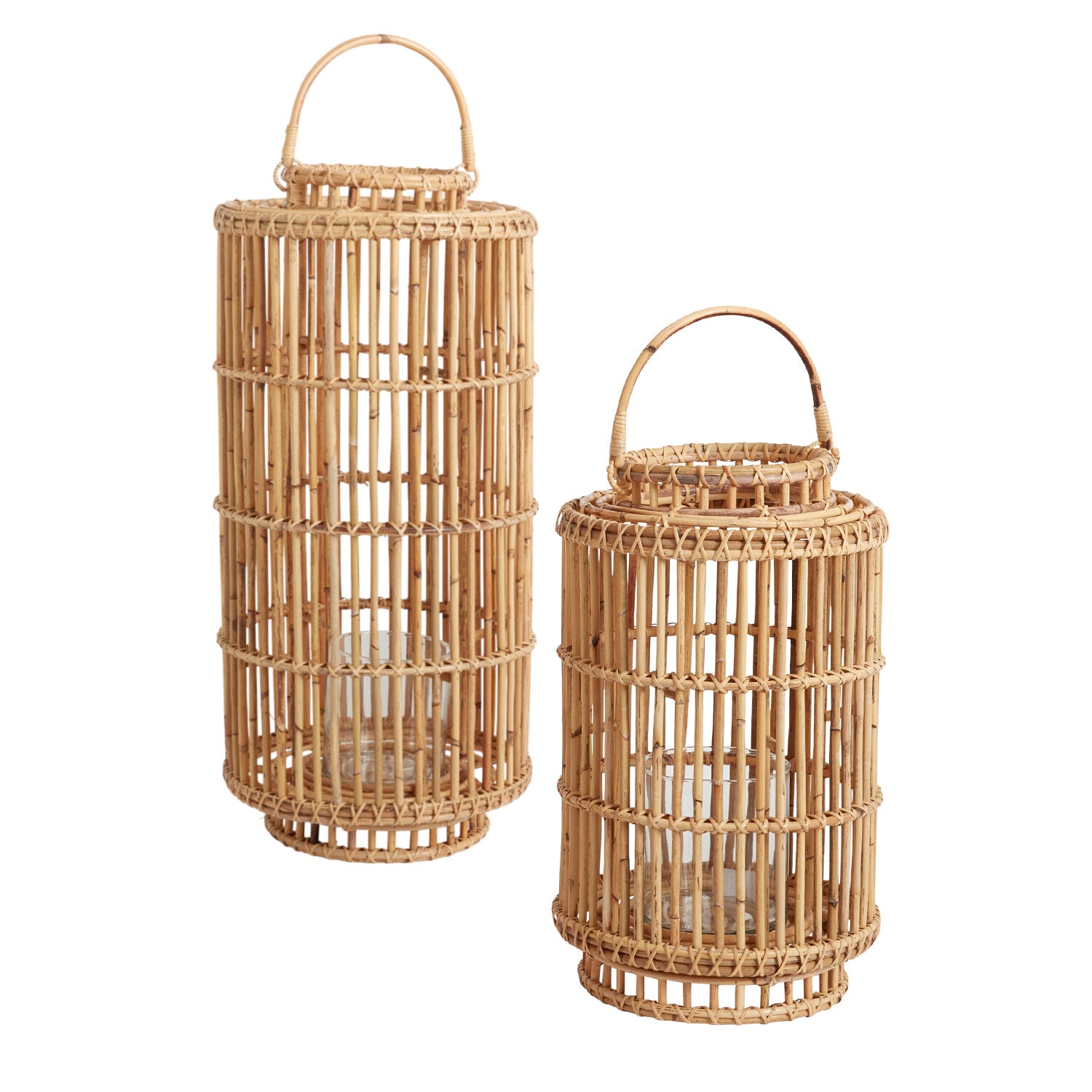 Two Accent Decor Tindra Lanterns, one tall and one short, crafted from handwoven rattan with glass holders and handles, sit side by side on a white background—ideal for adding warm ambiance to weddings or special events.