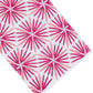 The Radiant Bath Collection by Haute Home showcases a crisp white linen surface adorned with a repeating pattern of pink and red starburst shapes, arranged diagonally to bring a vibrant flair to sophisticated home décor.