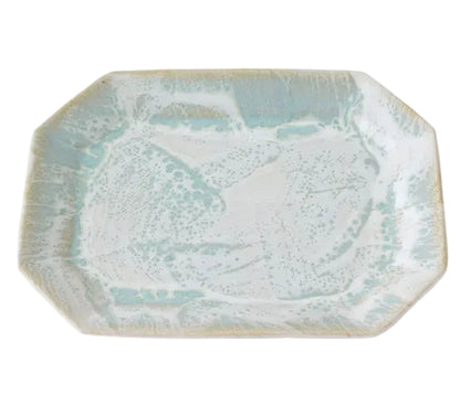 The Brushstroke Tray Collection by Paul Schneider Ceramics features a rectangular ceramic tray with gently rounded corners and a light blue and white speckled glaze inspired by modern design.