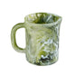 The Nashi Home Serveware Collection, Forest by Nashi Home features a handled ceramic pitcher with a green, white, and black marbled pattern—perfect as a striking home decor accent or unique serving piece. Shown against a white background.