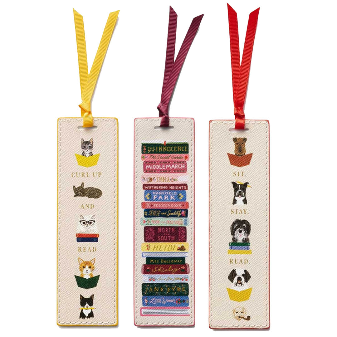 The Rifle Paper Co. Bookmark Collection includes three illustrated bookmarks with grosgrain ribbons: cats reading, classic books stack, and dogs reading—all in a whimsical design with unique reading-themed phrases at the bottom.