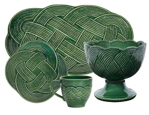 The Juliska Le Panier Mystic Knot Basil Dinnerware and Serveware Collection features plates, a mug, and a bowl with an intricate braided rope pattern—ideal for holiday gatherings or stylish ceramic serveware.