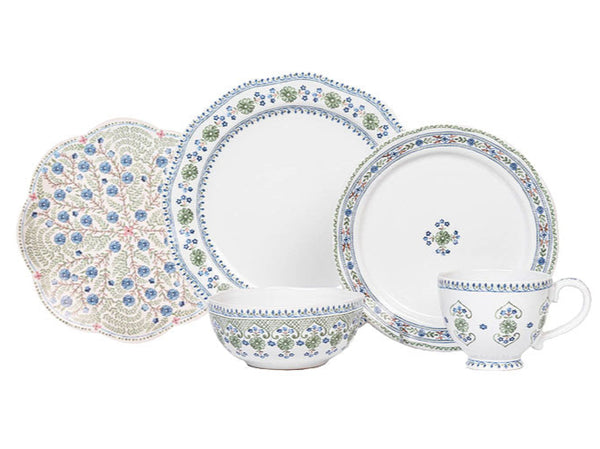 The Juliska Villa Seville Chambray Collection is a charming five-piece set of white decorative dishware with a blue and green floral motif, including a cup, bowl, dinner plate, side plate, and scalloped rim plate.