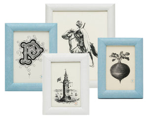 Four black and white illustrations—a decorative letter, rider, lighthouse, and beet—are presented in Pigeon & Poodle’s Oxford Frame Collection, featuring durable faux shagreen frames in blue and white.
