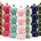 Five glossy Hive Bobbin Salt & Pepper Grinder Sets in brown, red, pink, light green, dark blue, and olive green are lined up in a row against a white background.