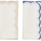 The Kim Seybert Lune Napkin Set features two folded white napkins—one with gold scalloped edges and one with blue—side by side on a white background, perfect for adding elegance to any table setting.