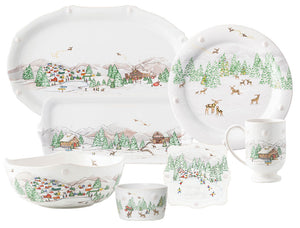The Juliska Berry & Thread North Pole Dinnerware and Serveware Collection features white holiday plates, bowls, a mug, and a serving tray with charming winter village scenes—perfect for festive gatherings.