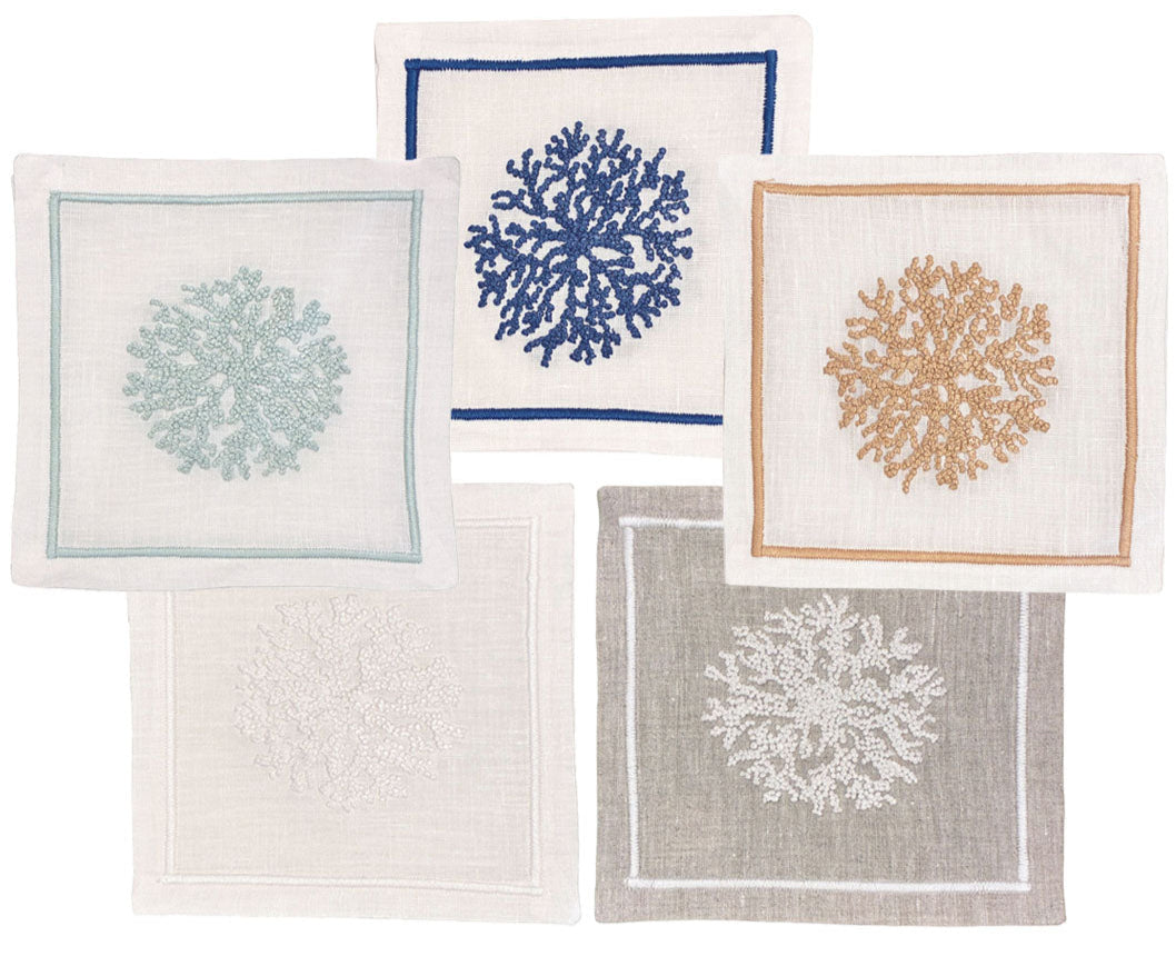 The Haute Home Sea Sponge Coaster Set includes 4 linen coasters, each hand embroidered with coral designs in blue, beige, light blue, white, and gray for a refined touch at your gatherings.