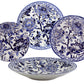 Four ceramic plates from the Pivoines Bleues Dinnerware and Serveware Collection by Gien France showcase intricate blue peony-inspired floral designs, with two at the back, one at the front, and one to the left.