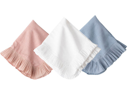 The Juliska Mademoiselle Napkin Set features three folded napkins with knife-pleat ruffle borders in pink, white, and blue, arranged side by side on a white background—ideal for a romantic tablescape.