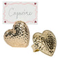 Two Berry & Thread Heart Napkin Rings and Place Card Holders by Juliska, featuring a hammered gold finish and a handwritten "Capucine" card bordered with pink and red hearts.