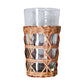 The Be Home Seagrass Rattan Cage Tumbler, from the Seagrass Rattan Cage Tumbler Collection, features a clear glass with a woven wicker holder around its base, adding rustic charm and shown against a plain white background.