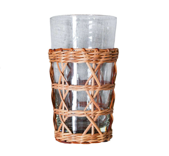 The Be Home Seagrass Rattan Cage Tumbler, from the Seagrass Rattan Cage Tumbler Collection, features a clear glass with a woven wicker holder around its base, adding rustic charm and shown against a plain white background.