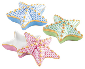 The Herend Starfish Box Collection features three ceramic star-shaped trinket boxes with removable lids in blue, green, and pink, each hand painted with gold accents.