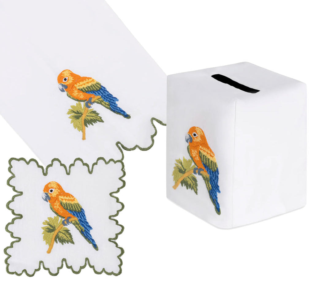 Haute Home Parrot Coaster & Bath Collection items including a square tissue box cover, a square coaster, and a hand towel, each embroidered with a colorful parrot perched on a branch.