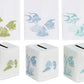 Deep Water Fish Bath Collection: three sets of premium linen towels and tissue box covers embroidered with coral reefs, fish, and seahorses in green, blue, or teal.