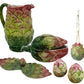 The Les Ottomans Artichoke Decor and Serveware Collection includes a hand-painted Italian ceramic pitcher, serving spoon, candle holder with candle, leaf-shaped dish, and two small bowls.