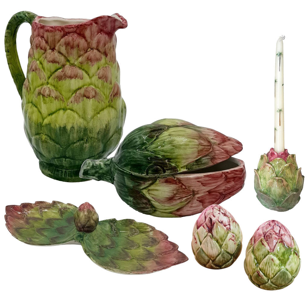 The Les Ottomans Artichoke Decor and Serveware Collection includes a hand-painted Italian ceramic pitcher, serving spoon, candle holder with candle, leaf-shaped dish, and two small bowls.