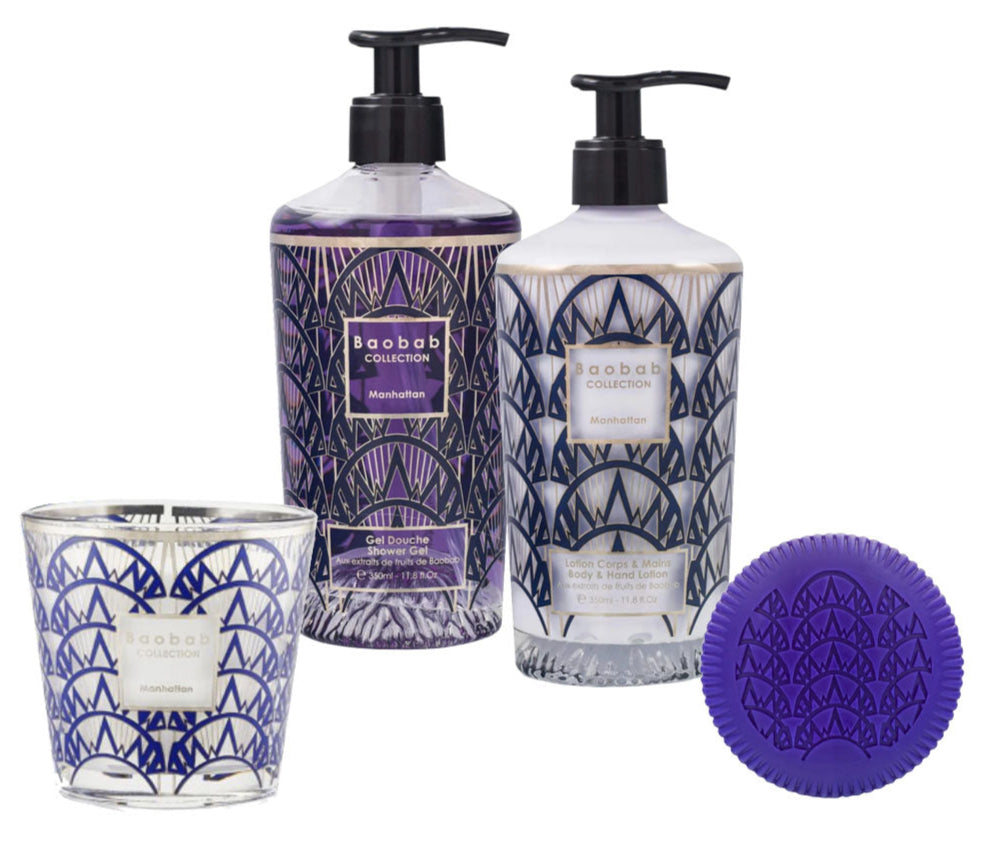 The Baobab Manhattan Body Wellness Collection includes a candle, shower gel, body cream, and round purple soap in purple and silver packaging with a fresh scent inspired by Central Park's vibrant energy.