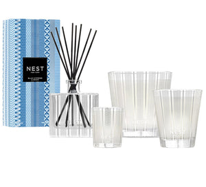 The Nest Blue Cypress & Snow Collection features a reed diffuser, three white winter candles in patterned glass holders, all presented in a blue patterned box.