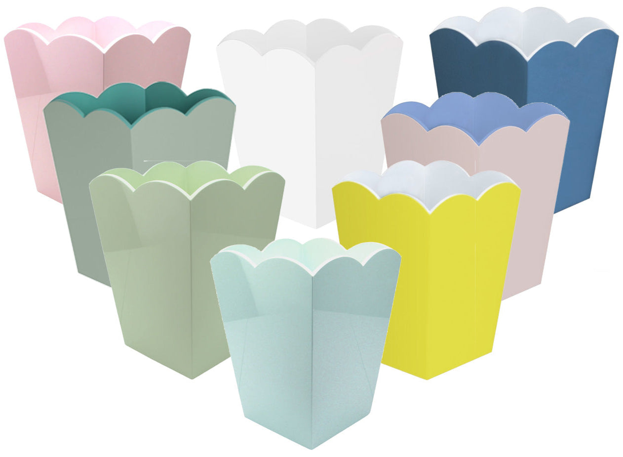 Eight pastel-hued scalloped-edge popcorn boxes—pink, green, yellow, blue, and white—are arranged on a white background, evoking the chic Addison Ross Scalloped Lacquer Waste Bin Collection.