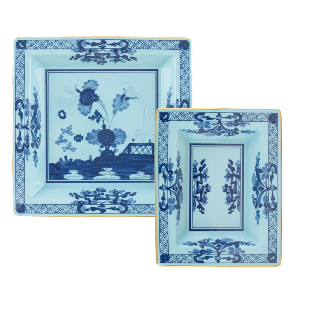 Two square ceramic trays from the Oriente Italiano Iris Tray Collection by Ginori 1735, showcasing light blue backgrounds, dark blue carnation floral motifs, yellow rims, and geometric border designs.