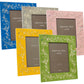 Five frames from the Addison Ross Chinoiserie Frame Collection, in blue, yellow, gray, green, and pink with a floral pattern and high-gloss lacquer finish are elegantly displayed upright.
