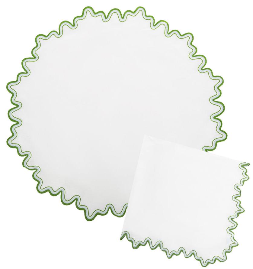 The Wave Tabletop Collection, Santorini by Matouk features round and square white linen napkins with wavy green-edged borders, OEKO-TEX certified—perfect for layering on embroidered tabletops.