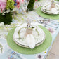 A spring table is set with the Kim Seybert Easter Bunny Napkin Ring on layered green-patterned plates, surrounded by glassware, cutlery, and florals—perfect for a charming seasonal decor.
