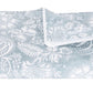 A folded light blue towel featuring a white floral pattern inspired by classic block print textiles from the Matouk Granada Bedding Collection, displayed on a white background.