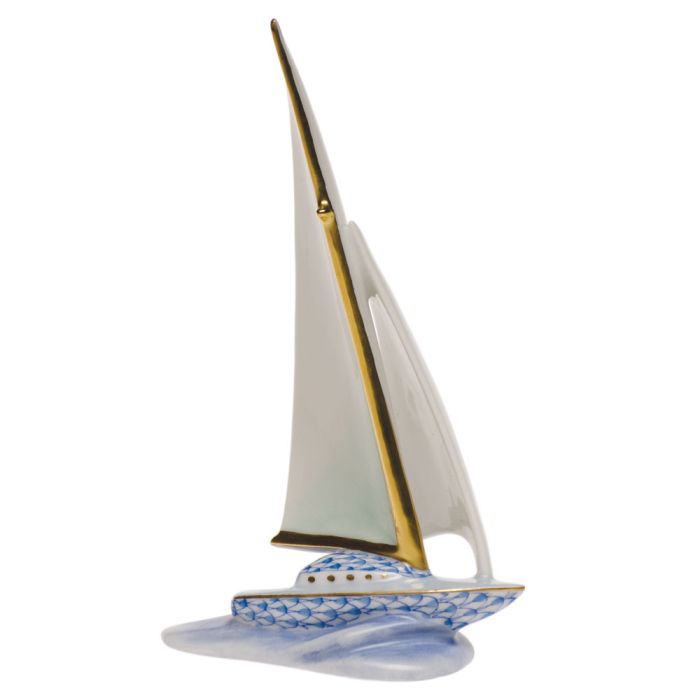 The Herend Sailboat features a tall white sail, gold accents, and a blue patterned hull on a water-like base—a timeless decorative collectible.