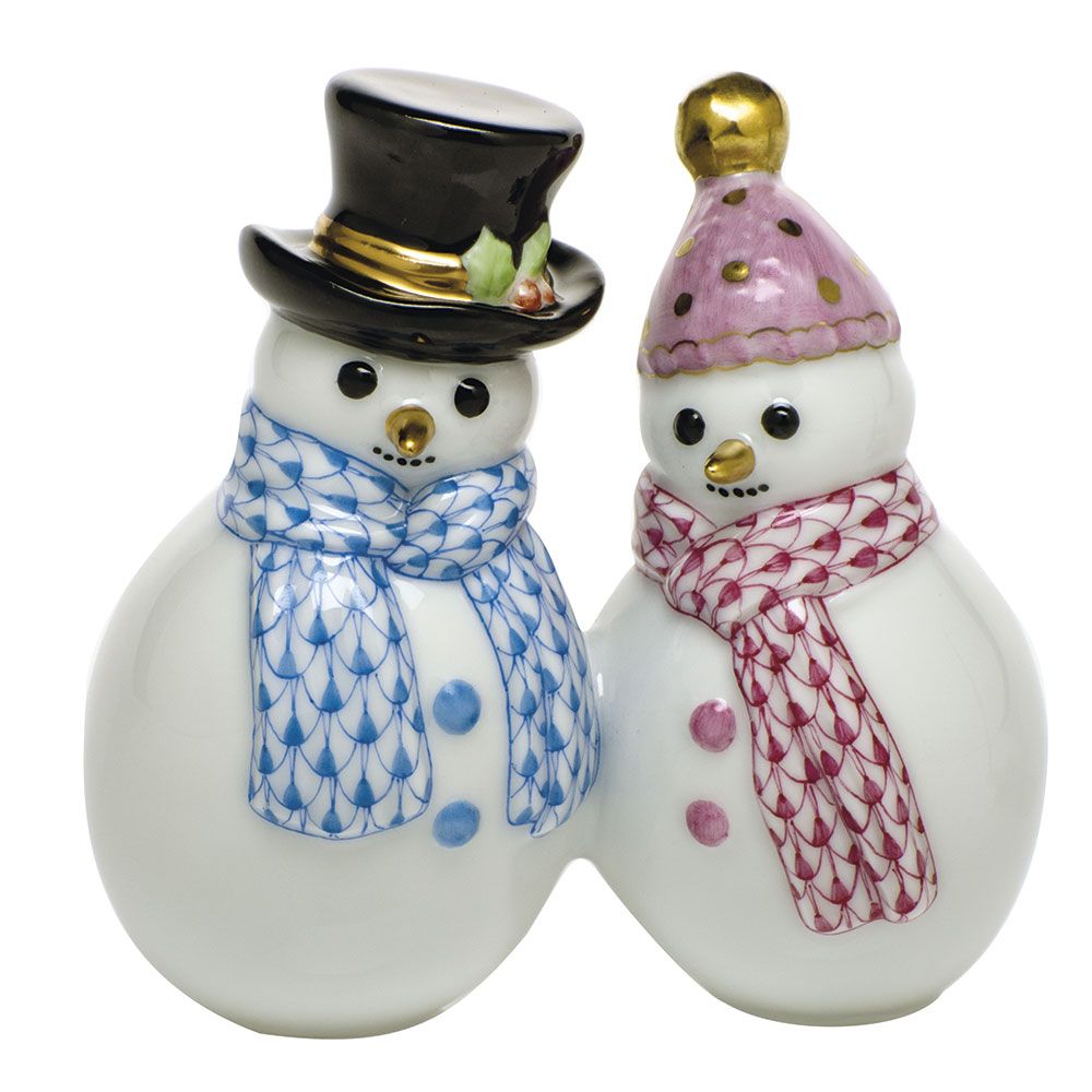 Two ceramic snowmen figurines from Herend’s Snowman Couple collection—one wearing a black hat with a blue scarf, the other featuring a pink hat and red scarf—stand side by side, making this charming set perfect for holiday décor or celebrating winter traditions.