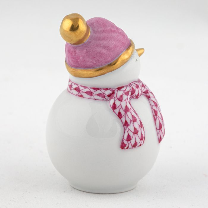 The Herend Snowman is a white ceramic figurine with a pink and gold hat and patterned pink scarf, making this collectible porcelain a timeless decorative accent against a plain white background.
