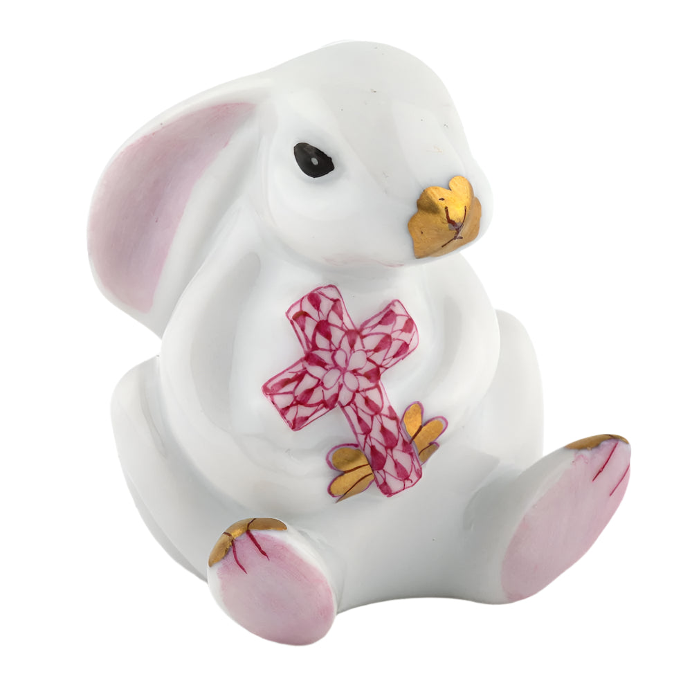 The Herend Bunny with Cross is an exquisite ceramic white rabbit figurine by Herend featuring hand-painted designs, a pink patterned cross, and elegant gold accents on ears, paws, and nose. Seated upright, it embodies artistic appreciation in every detail.