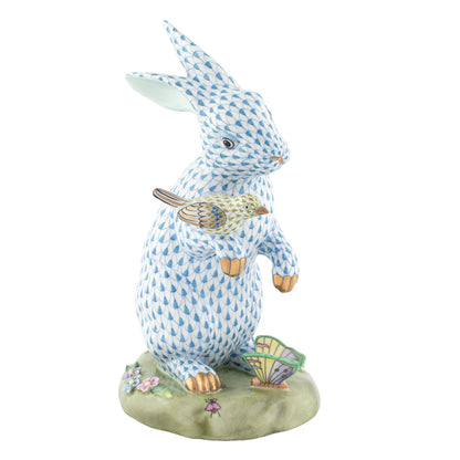 The Herend Reserve Collection Anniversary Bunny is a limited edition ceramic figurine featuring a blue patterned rabbit holding a bird, standing on a decorated floral and fan base with exquisite hand-painted designs inspired by Herend porcelain.