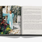 An open book, "Villa Treville Positano" by Assouline, displays a man in a blue and white striped robe standing beside a stone wall and lush plants on the left page, capturing the tranquil charm of an Amalfi Coast boutique hotel, with accompanying text on the right page.