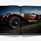A striking tribute to automotive history and luxury photography, Vintage Cars (2nd Edition) by Assouline features a dramatic photo of a vintage convertible with wood paneling displayed across an open book, viewed from a low angle outdoors.