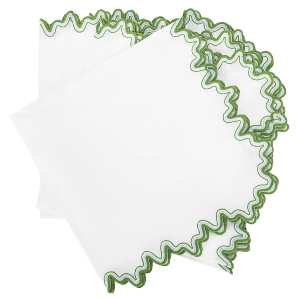 The Matouk Wave Tabletop Collection, Santorini features white linen napkins with wavy green-stitched edges—neatly stacked for an elegant, embroidered accent to any setting.