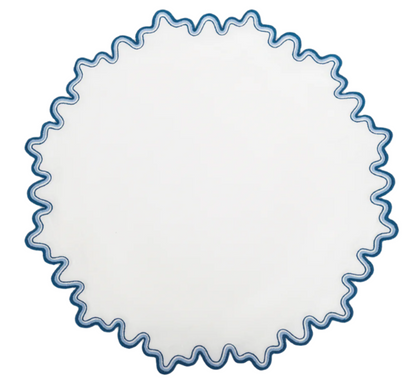 The Matouk Wave Tabletop Collection, Aquarius, features a round white plate with a blue wavy edge—ideal for pairing with linen napkins or an embroidered tablecloth for an elegant dining touch.