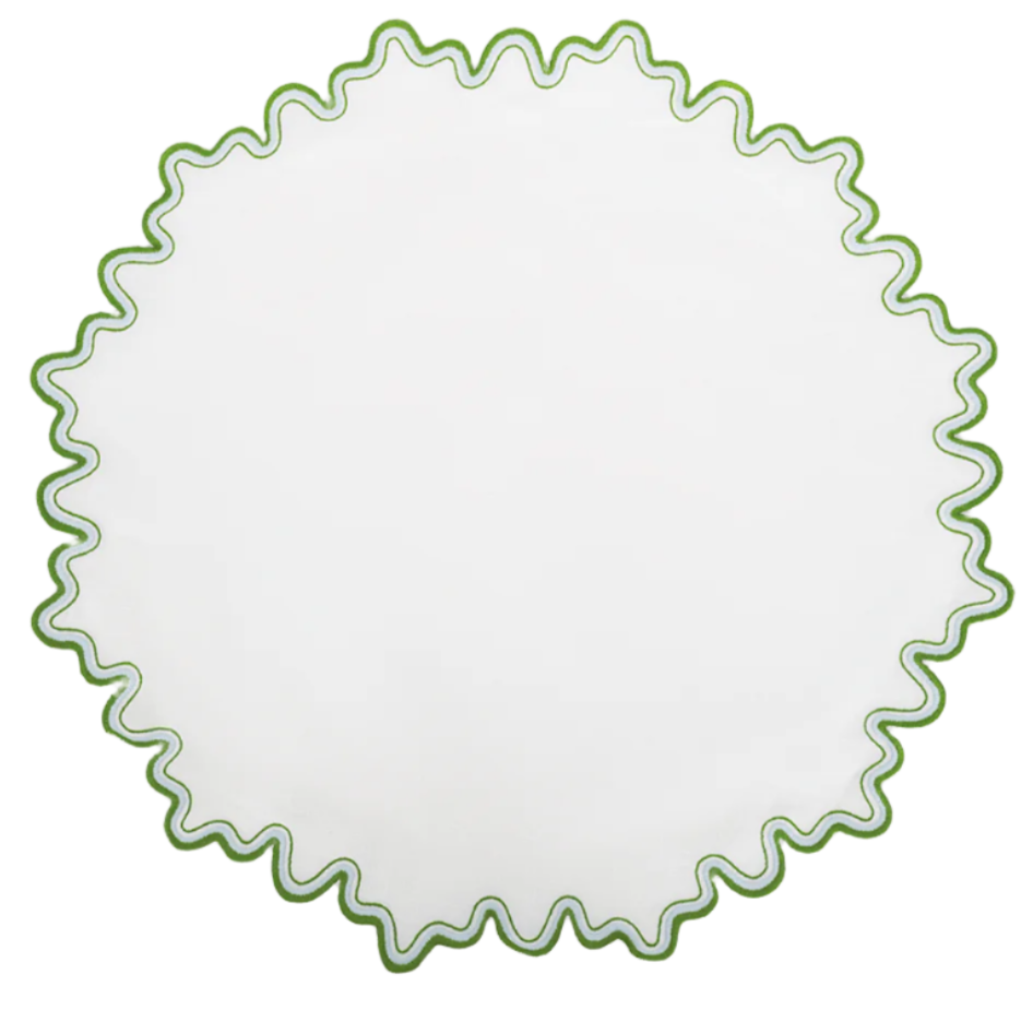The Wave Tabletop Collection in Santorini by Matouk features a round white linen placemat with a wavy green border, ideal for an elegant embroidered table. OEKO-TEX certified for your peace of mind.