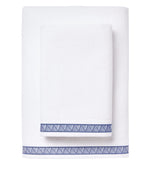 Two ultra-absorbent towels from the Averylily Weave Bath Collection, one large and one small in white Aegean Cotton, feature a blue geometric edge. Both are stacked, perfect for everyday use.