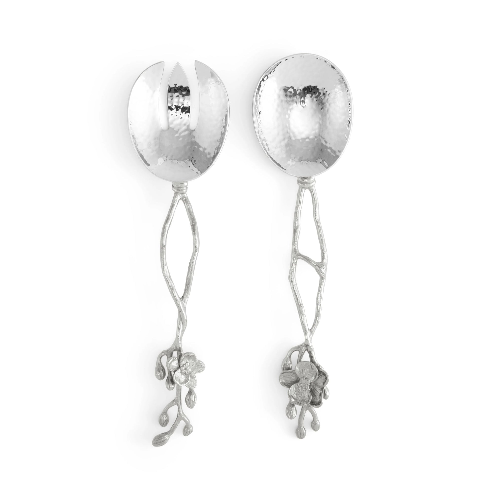 Two metal serving spoons from the Michael Aram White Orchid Serveware Collection feature hammered bowls and decorative floral, branch-inspired handles for a touch of mystery.