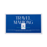 The Mahjong House Travel Mahjong Set comes in a blue and white box and includes lightweight mahjong tiles, racks, pushers, cards, dice, and a travel bag for easy portability.