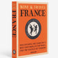 The hardcover book "Wine & Travel France" by Assouline, adorned with an orange cover and a circular illustration, delves into French vineyards, wines, and terroir. It offers insights on wine tourism with contributions from Enrico Bernardo.