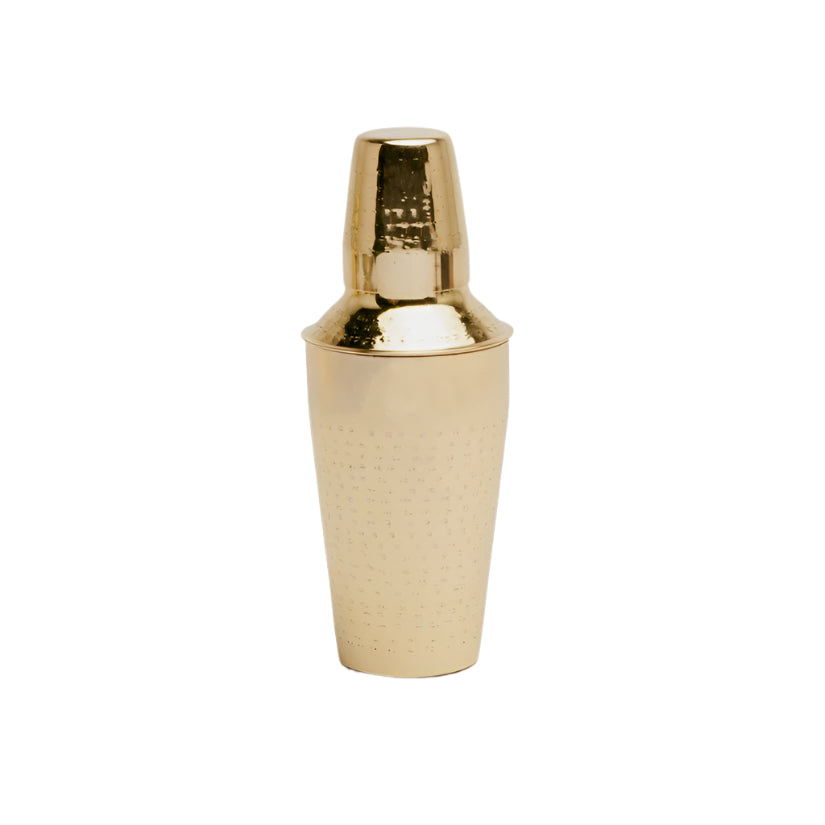 The Blue Pheasant Winsford Barware cocktail shaker in shiny brass, featuring a crisscross-etched texture, stands upright on a white background—an ideal addition to any modern bar.