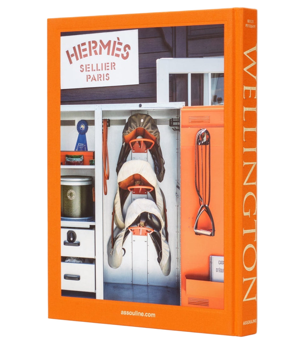 The book "Wellington: The World of Horses" by Assouline features an orange-bordered cover with a tidy locker of equestrian gear—ideal for fans of Wellington, Florida’s famous Winter Equestrian Festival.