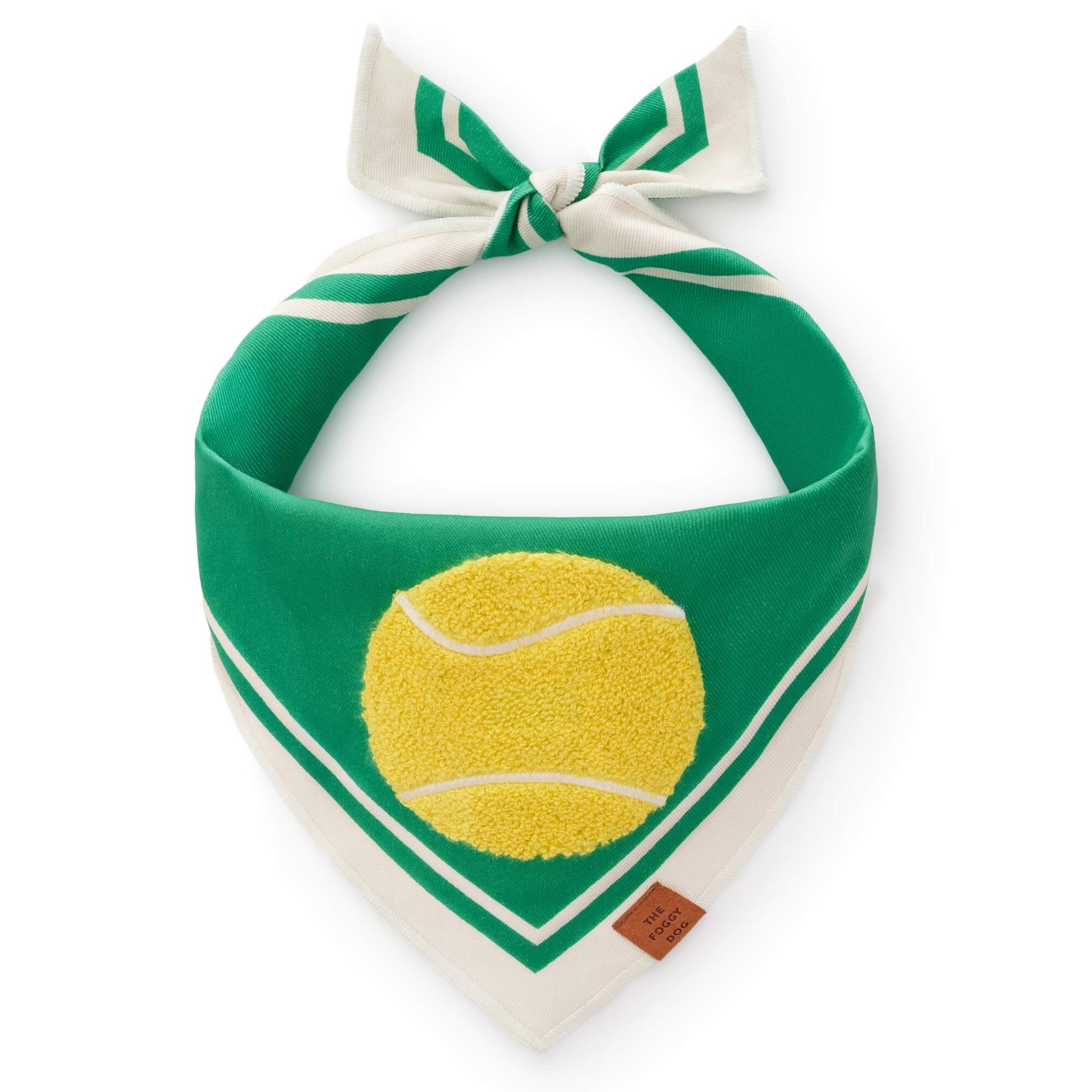 The Foggy Dog Tennis Applique Dog Bandana features green and white fabric with a yellow tennis ball design, a small brown tag, and is tied in a knot at the top.