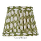 A pleated fabric lampshade with a green and white geometric pattern, part of the Zafferano x Fermoie Poldina Lampshade Collection by Zafferano America. Text says "Green Wicker.